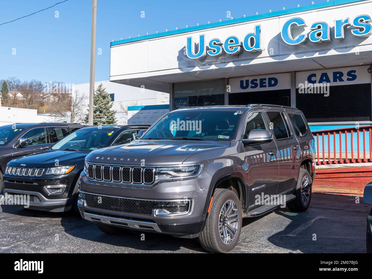 Two used Jeeps, a Cherokee and a Wagoneer for sale at a dealership in