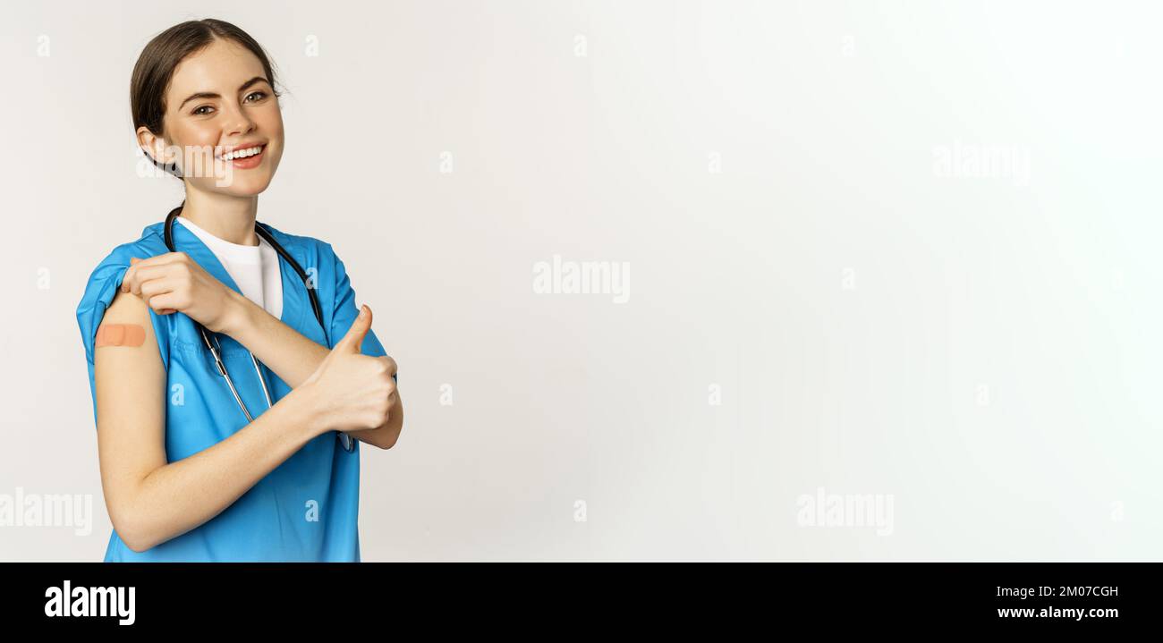 Happy smiling medical worker, doctor or nurse showing her shoulder ...