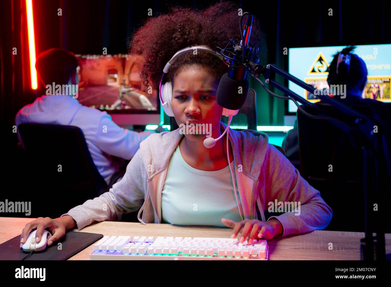 Young African American woman wearing headset play video game and live streaming online with microphone at home, gaming and esport for competition or c Stock Photo