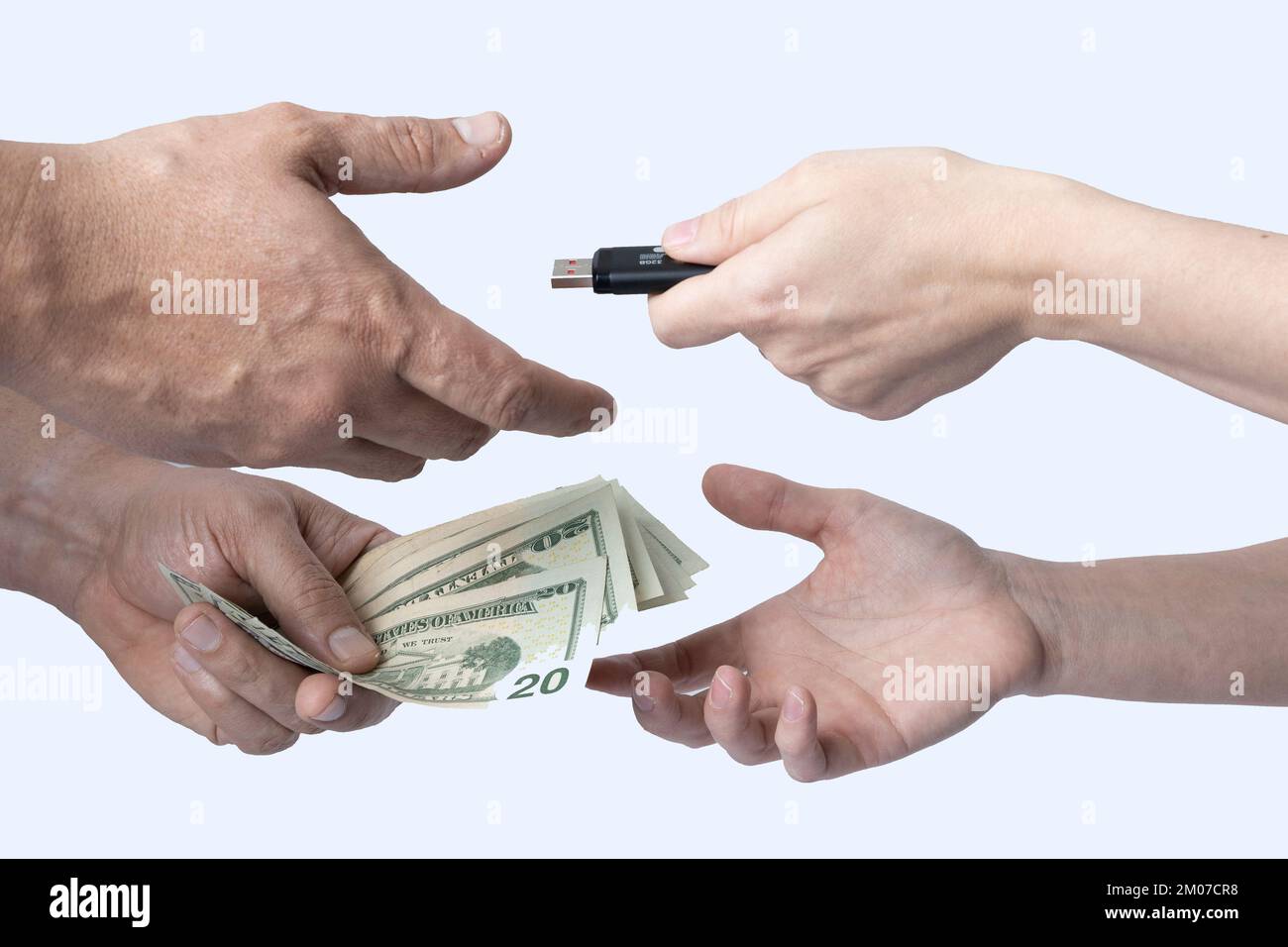 Exchange a storage device for cash between two individuals where only their hands and forearms are visible on a white background. Stock Photo