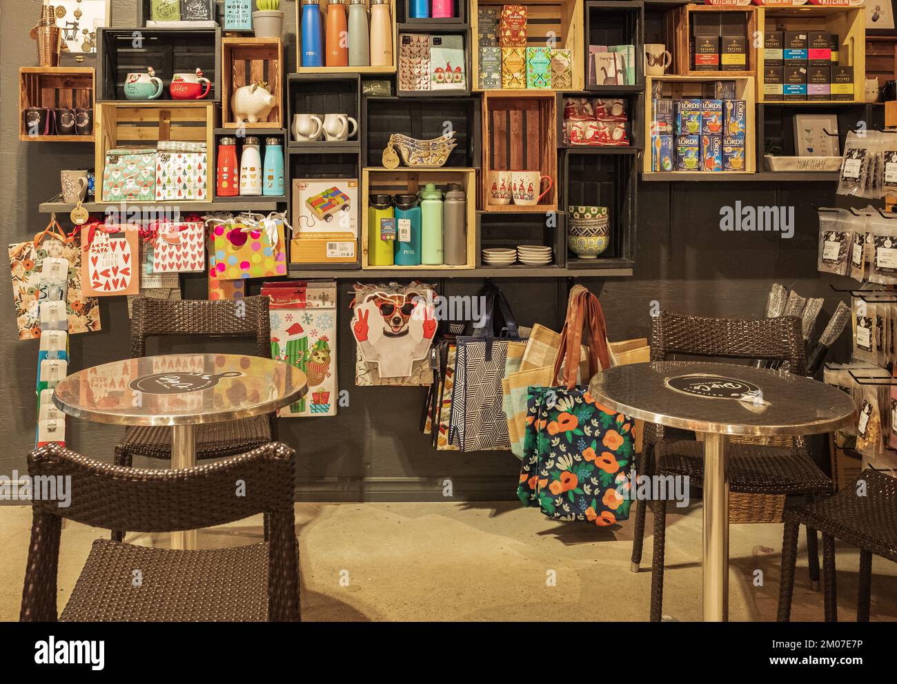 Small coffee shop interior. Wooden shelves with different goods and personal hygiene or cosmetics products in store. Eco-friendly shopping at local sm Stock Photo