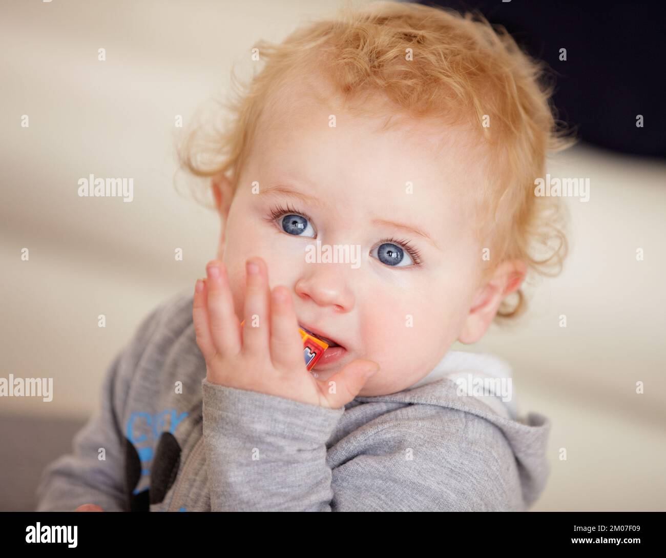 Tiny cutie. Cute baby boy looking up while sitting on the floor. Stock Photo
