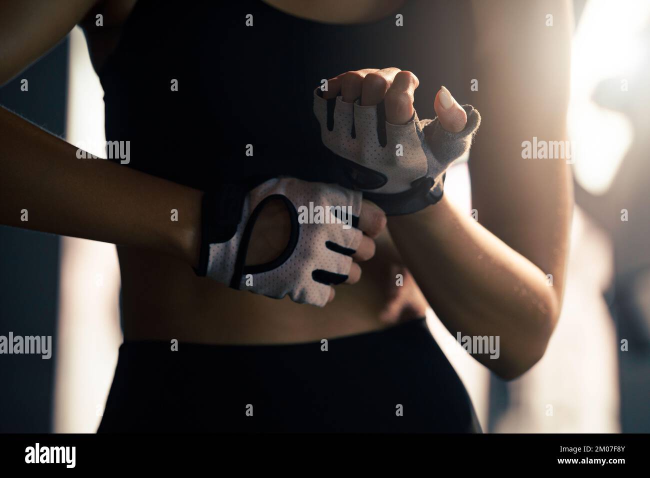 Woman put fitness gloves  for exercise at gym. Stock Photo