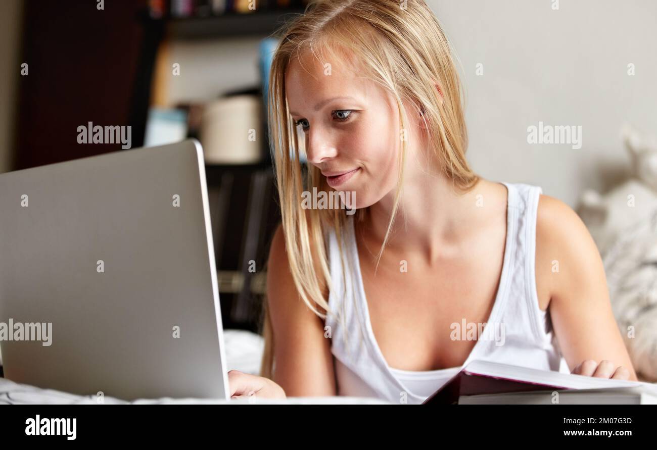 Breezing through her assignment. Young college student working on an assignment at home. Stock Photo