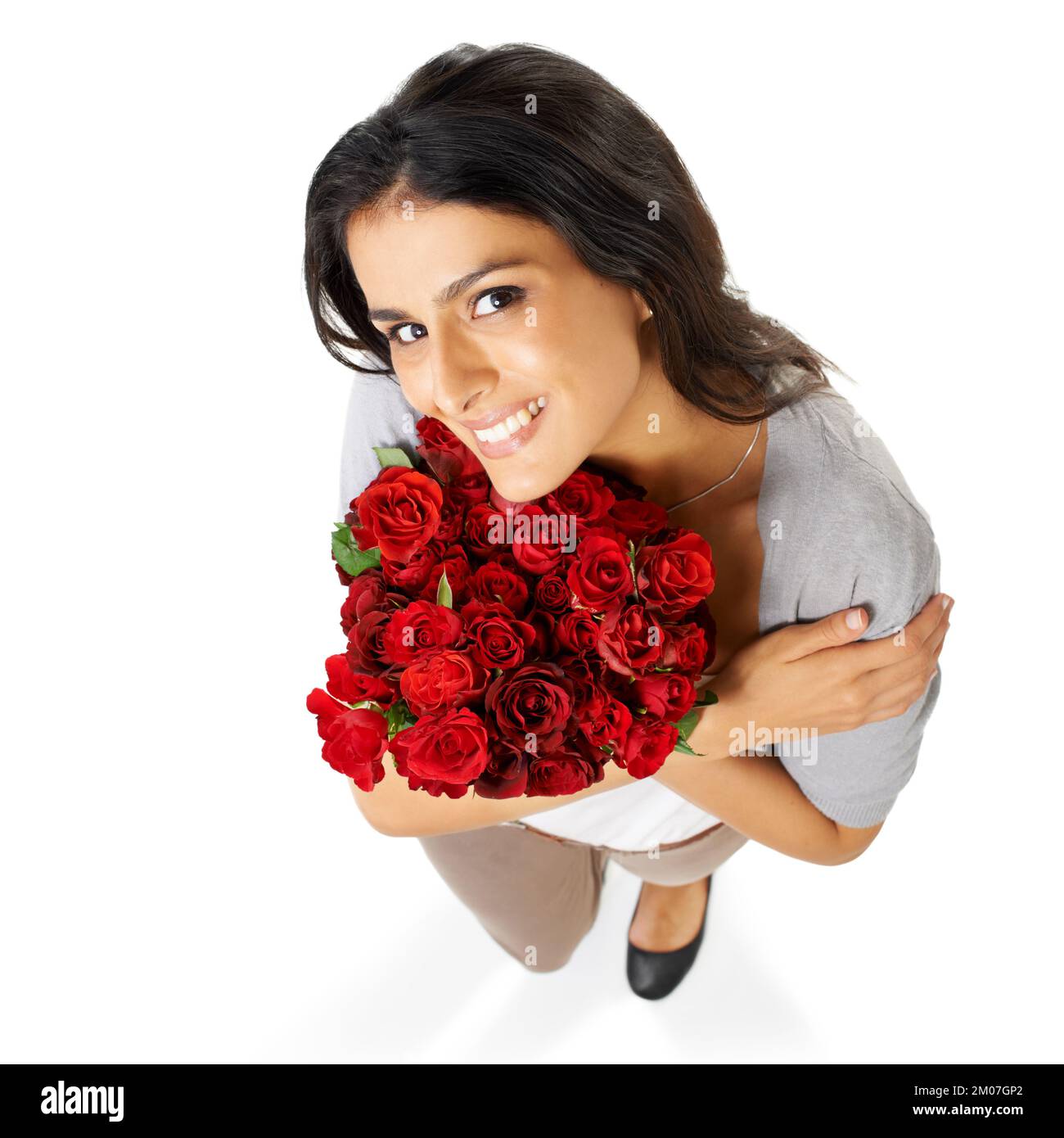 He loves me. A beautiful woman holding a bouquet of roses isolated on a white background. Stock Photo