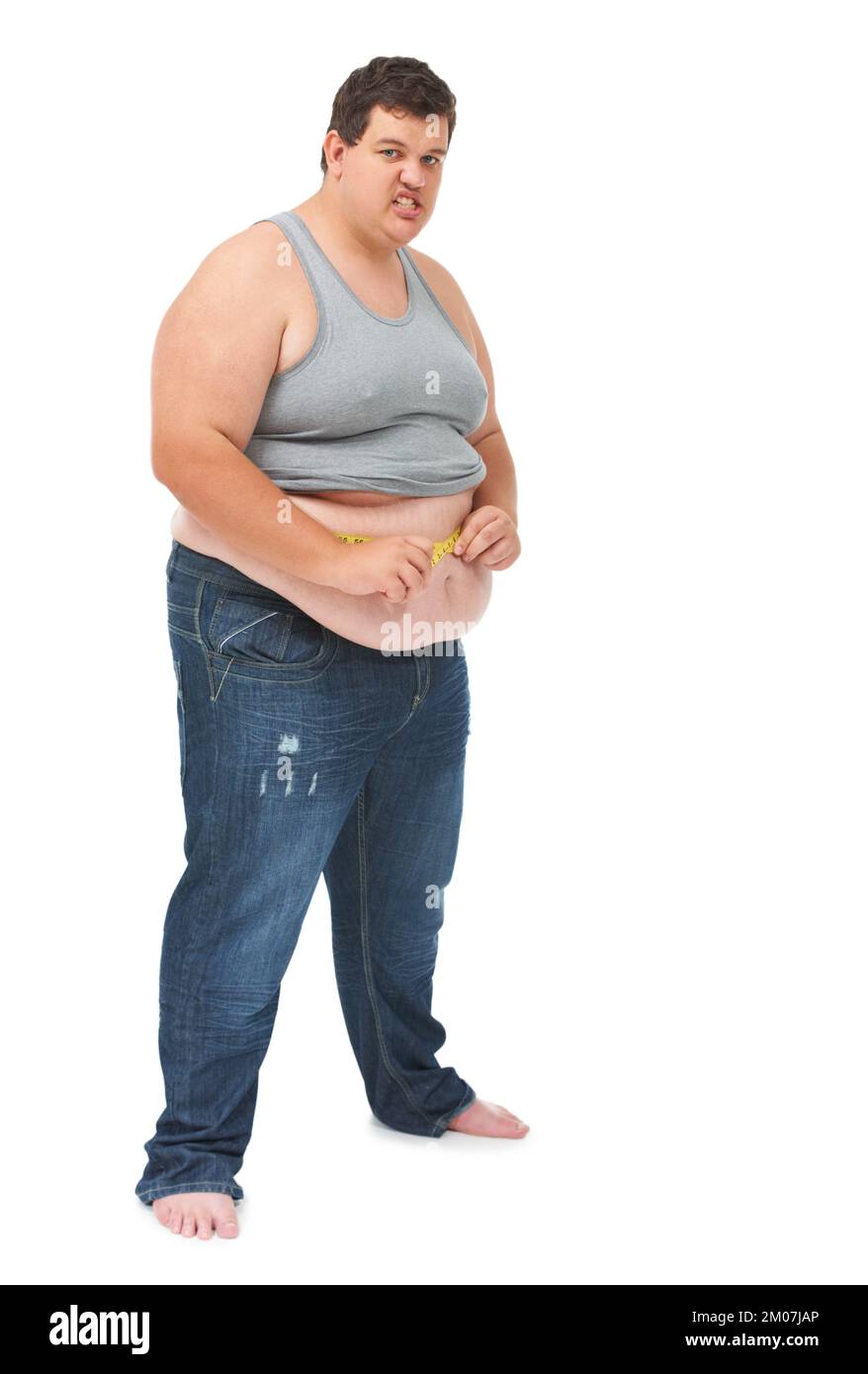 Not the result he wanted. Portrait of an obese young man measuring his waist with a measuring tape against a white background. Stock Photo