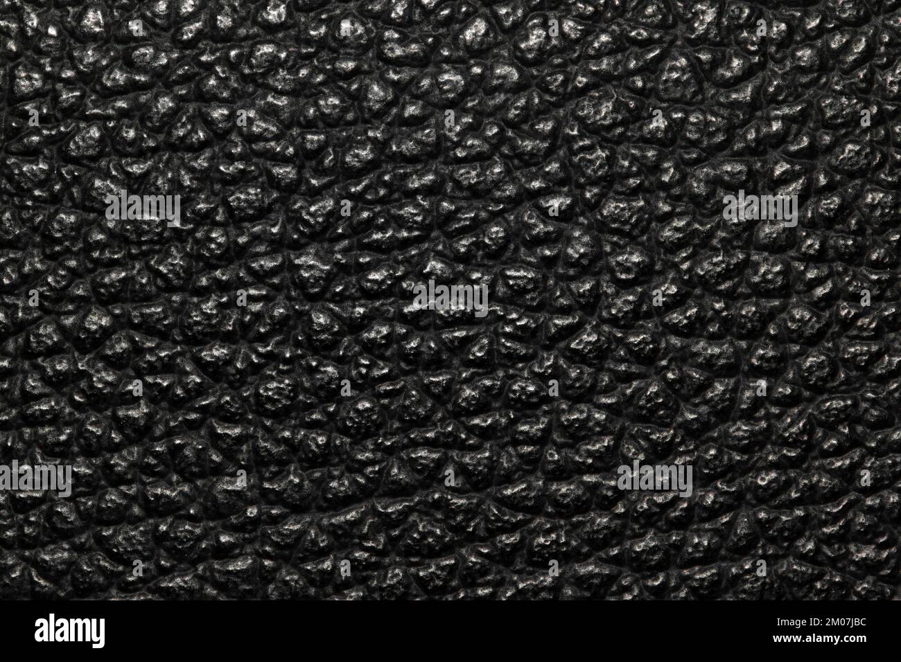 Dark black bumpy textured background image with highlights. Rough leather or animal skin appearance. Stock Photo