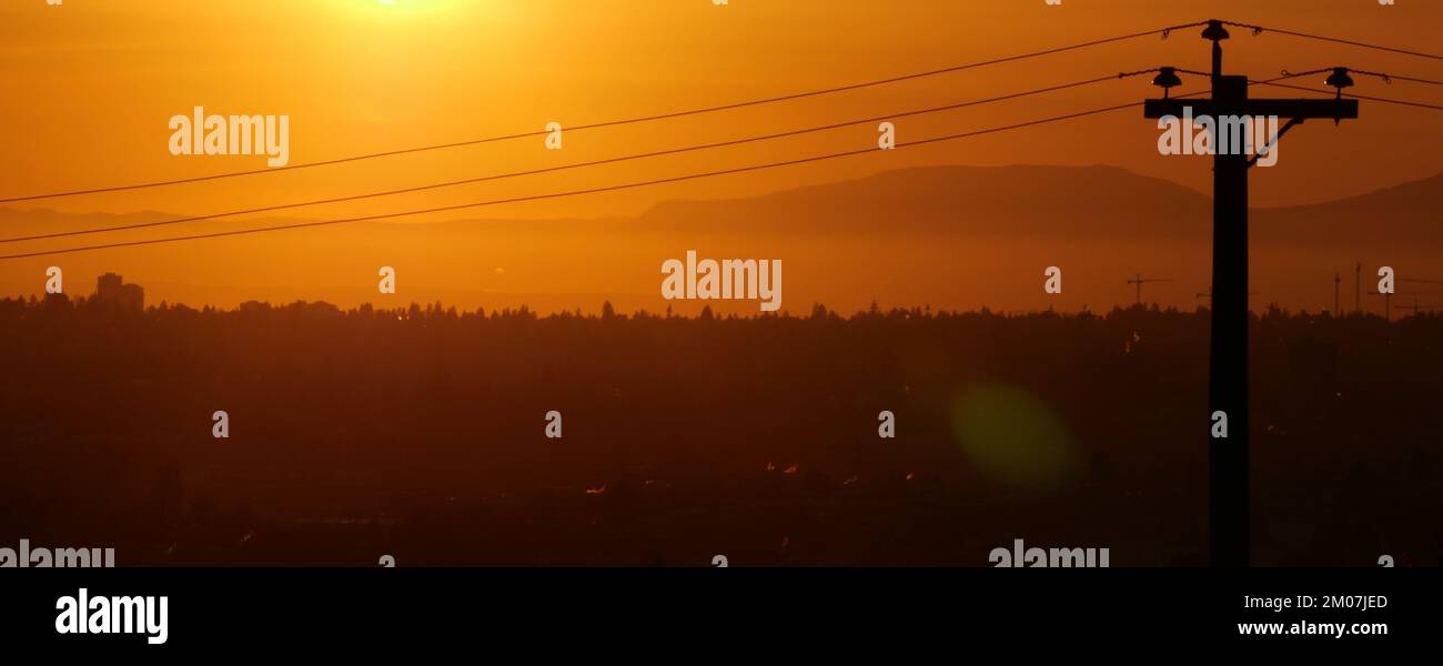 Silhouette of an electric wire pole during a beautiful sunset over