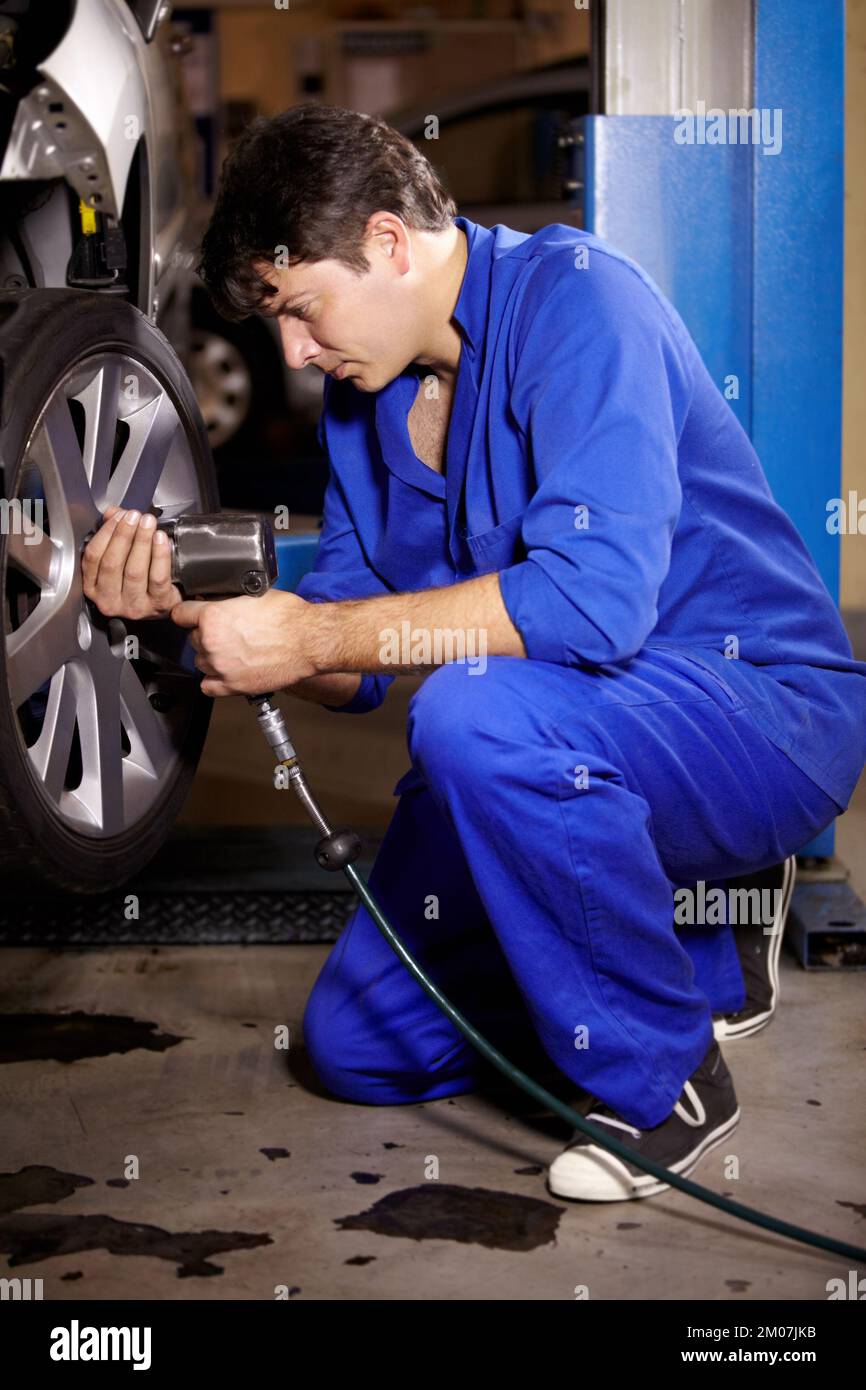 Fitting some new tyres. A male mechanic working on the wheel of a car