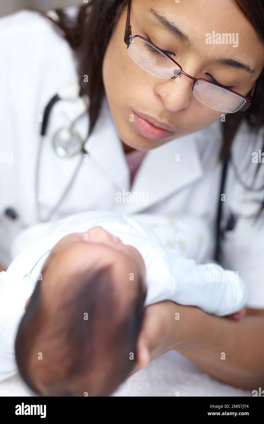 Going for her annual checkup. A young female doctor examining an infant who has a cleft palate. Stock Photo