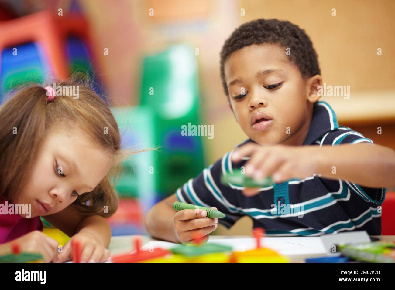 Learning and developing. Pre-school ethnic boy and girl scribbling and ...