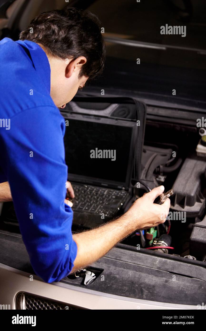 Running diagnostics. A male mechanic running electrical diagnostics on