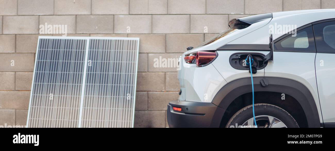Charging electric car from home photovoltaics power station ,sustainable and economic transportation concept. Stock Photo