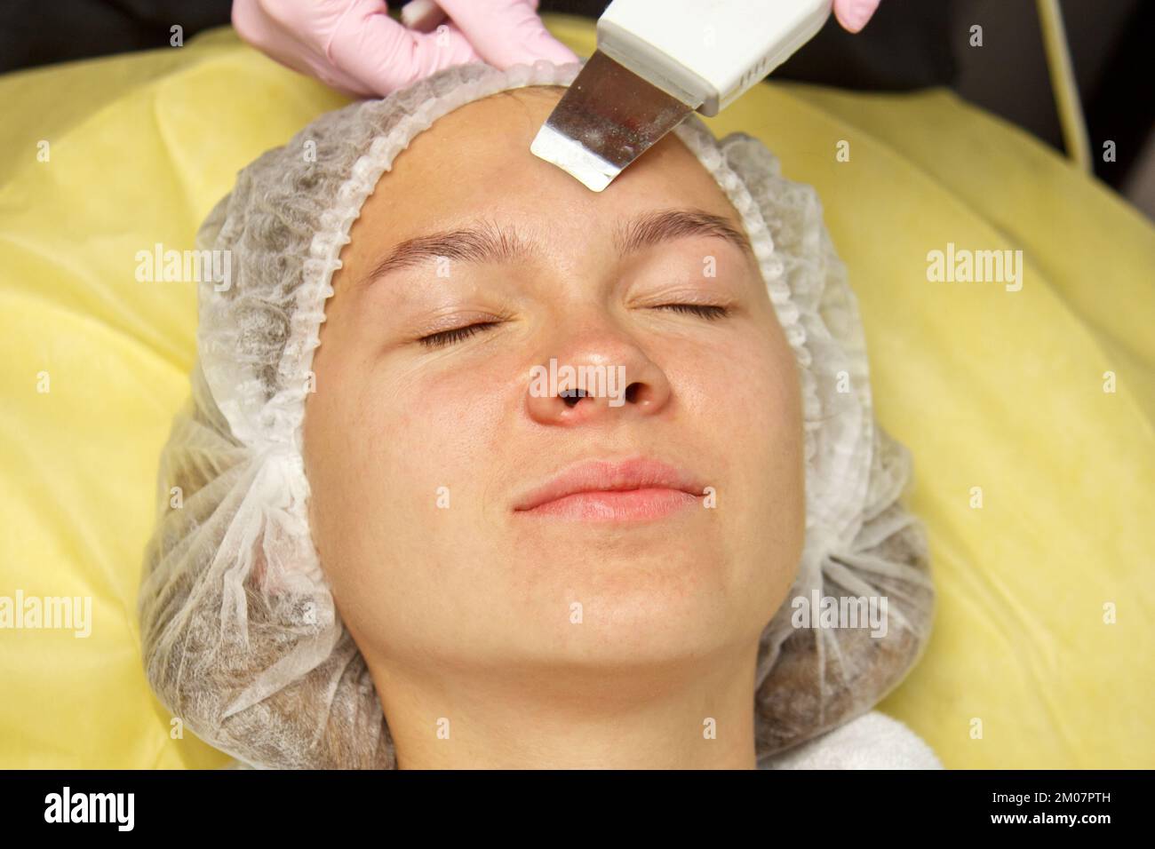 closeup. Ultrasonic face cleaning. Modern equipment. Beautician does cosmetic procedure on