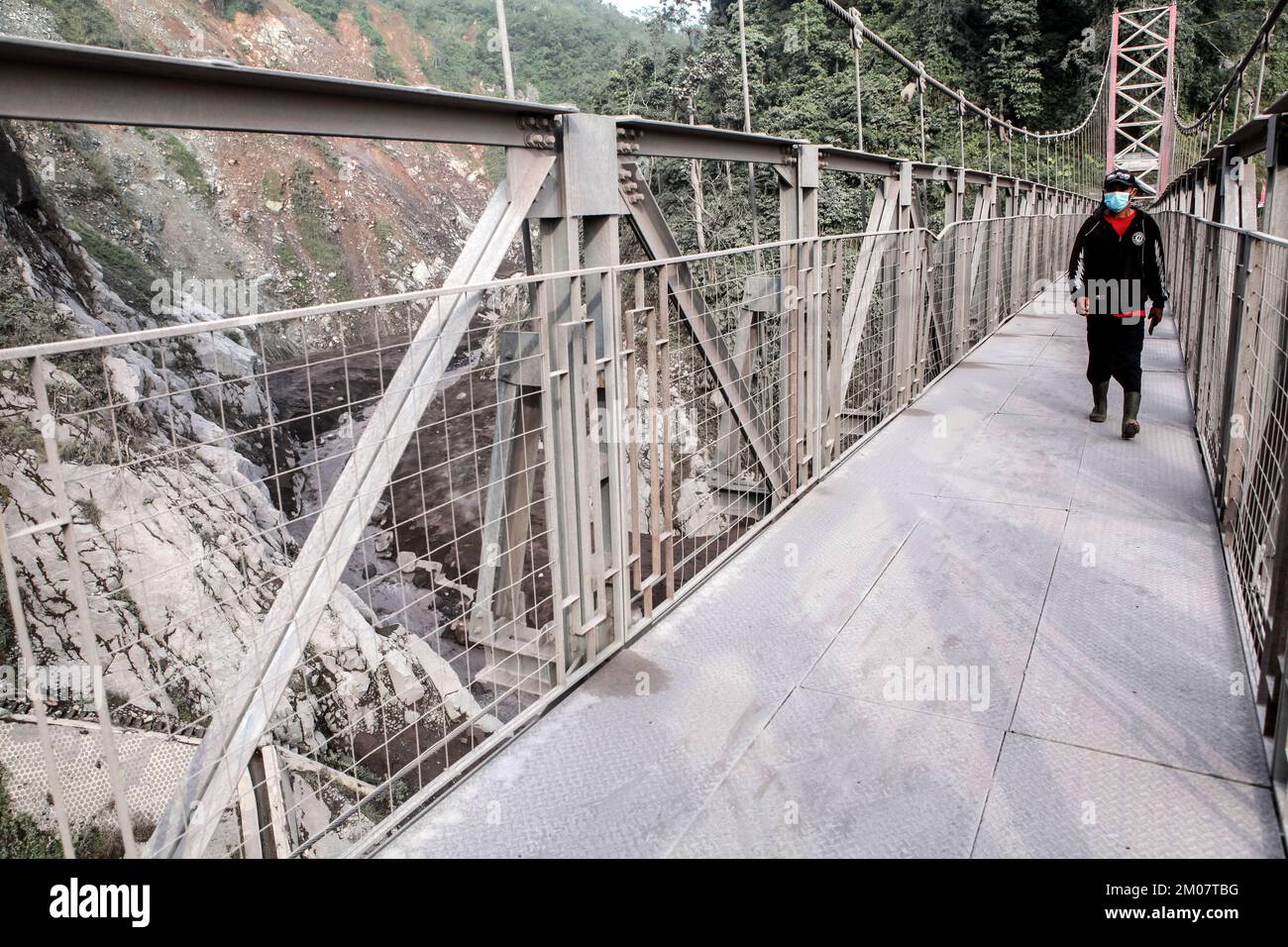 Lumajang, Indonesia. 5th Dec, 2022. A man walks on a bridge covered in volcanic materials after the eruption of Mount Semeru in Lumajang, East Java, Indonesia, Dec. 5, 2022. Semeru volcano on Indonesia's Java island erupted on Sunday, spewing a 1.5-km high ash column, authorities said. Credit: Bayu Novanta/Xinhua/Alamy Live News Stock Photo