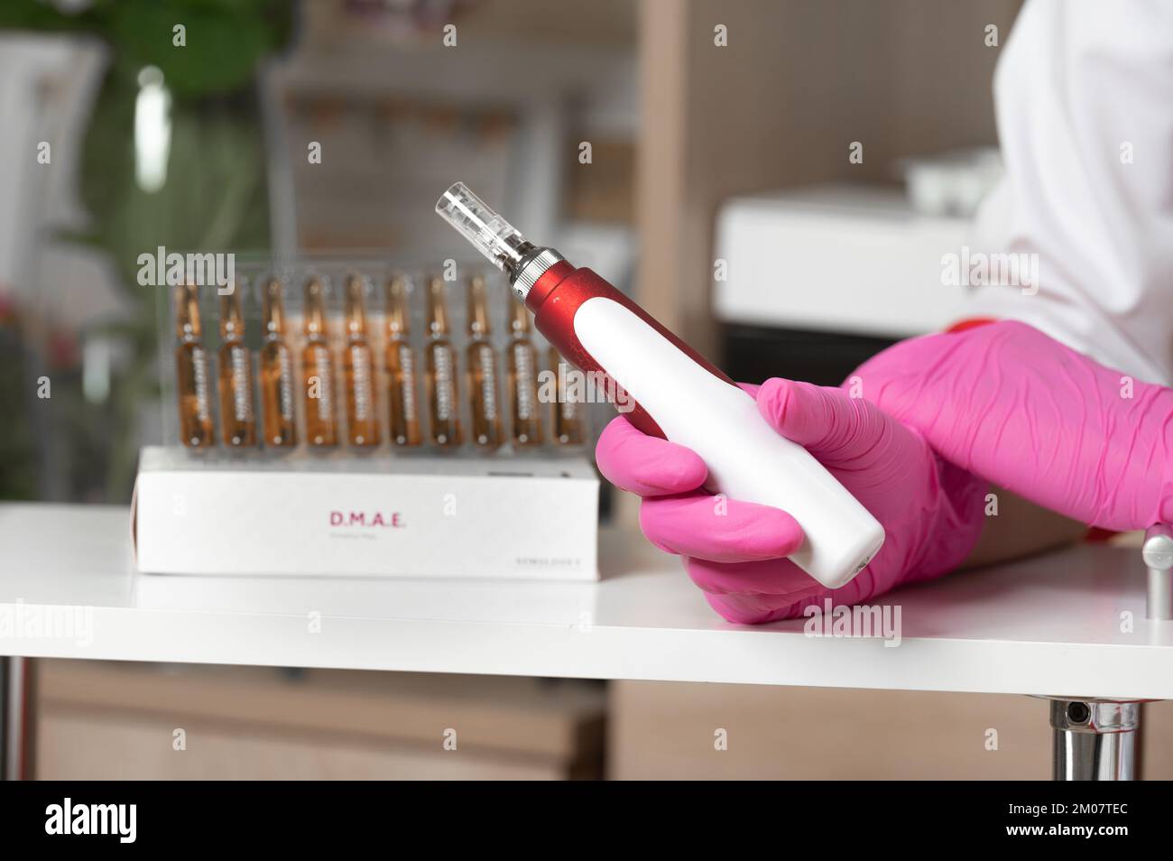 The cosmetologist holds in his hands a dermapen, a tool for mesotherapy