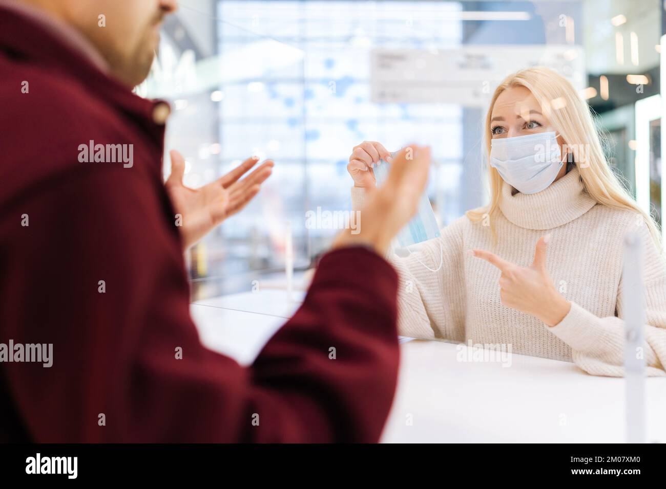 Rear view from shoulder of unrecognizable baffled man talking through