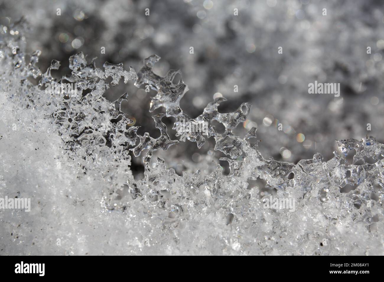 ice texture, melting snow, icing. Frozen snowflakes, icicles and a river water. Ice formations Stock Photo