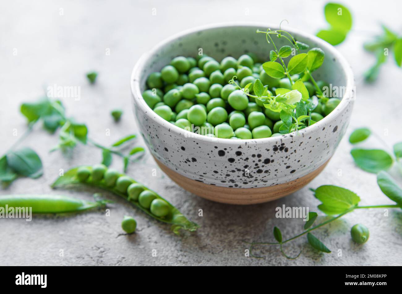 Bowl with young fresh juicy pods of green peas. Healthy organic food