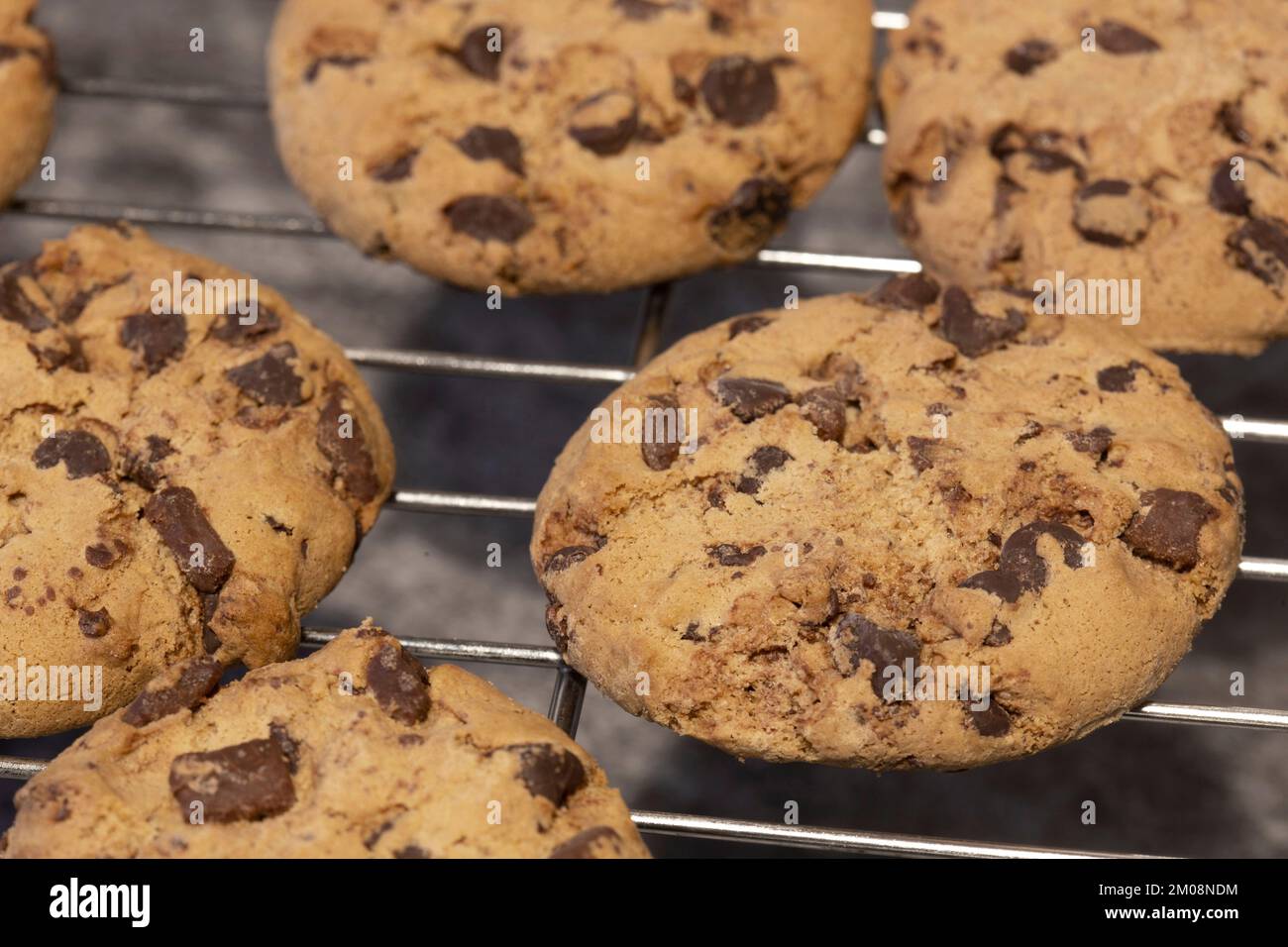 Homemade chocolate chip cookies on a cooling rack. On a dark stone background Stock Photo