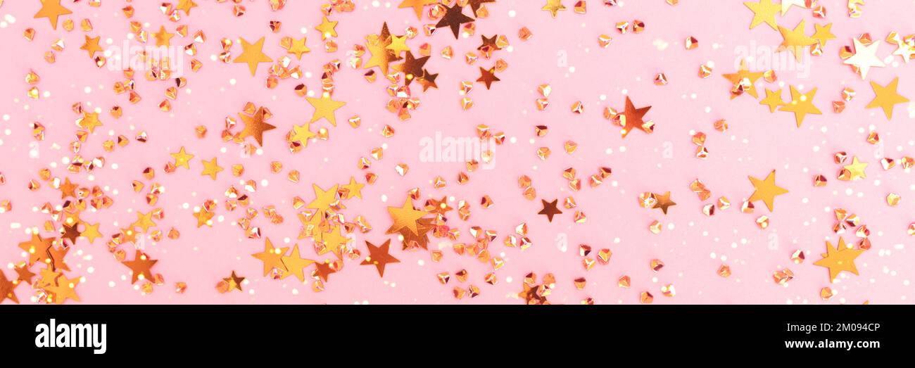 Banner with shiny gold colored stars and crystals confetti on a pink ...