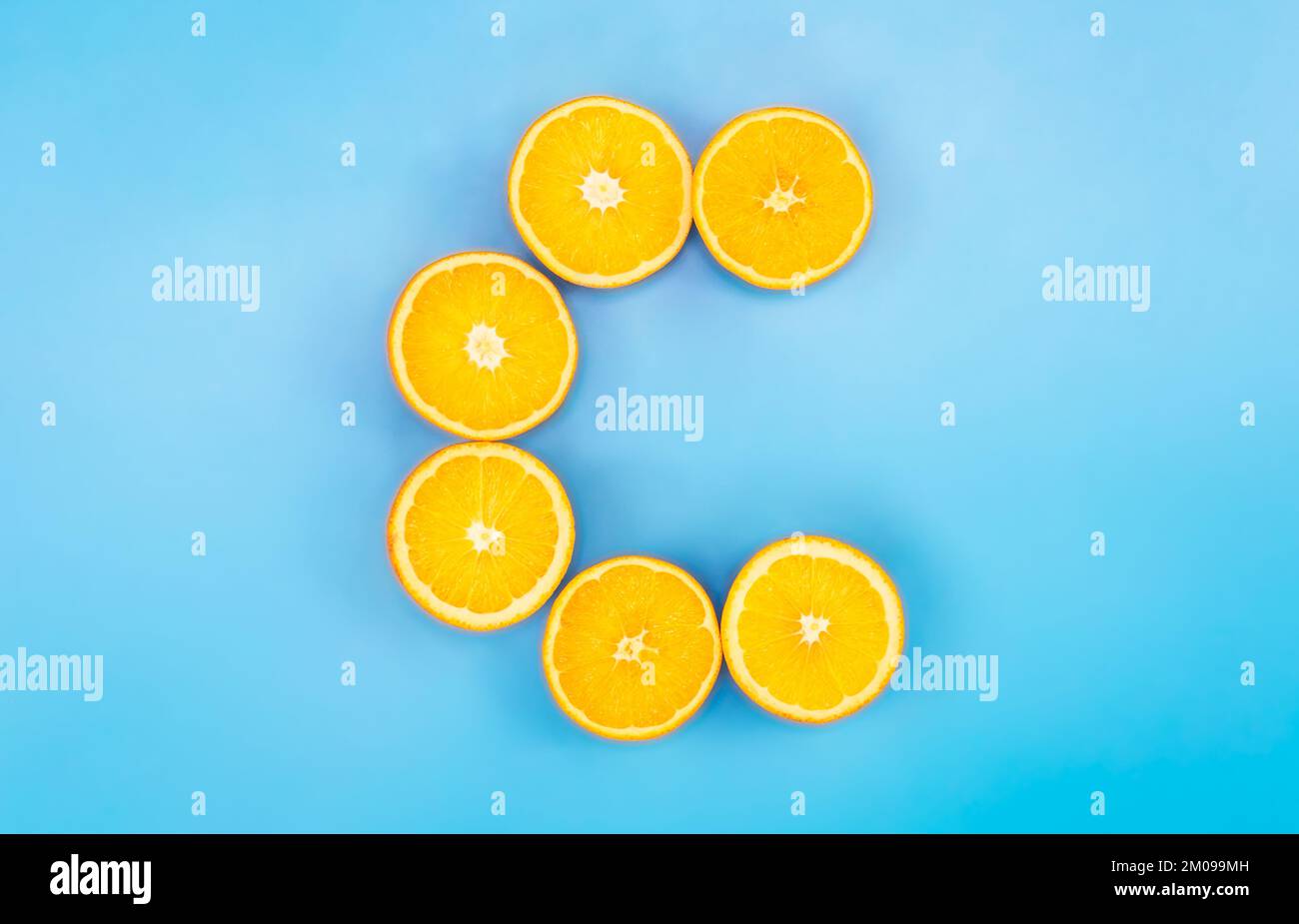 Fresh orange, vitamin C, letter C made of citrus fruits on blue ...