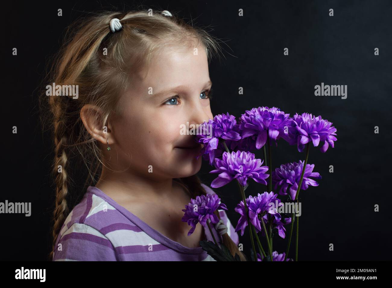 Close-up portrait of adorable little girl with a bouquet of flowers ...
