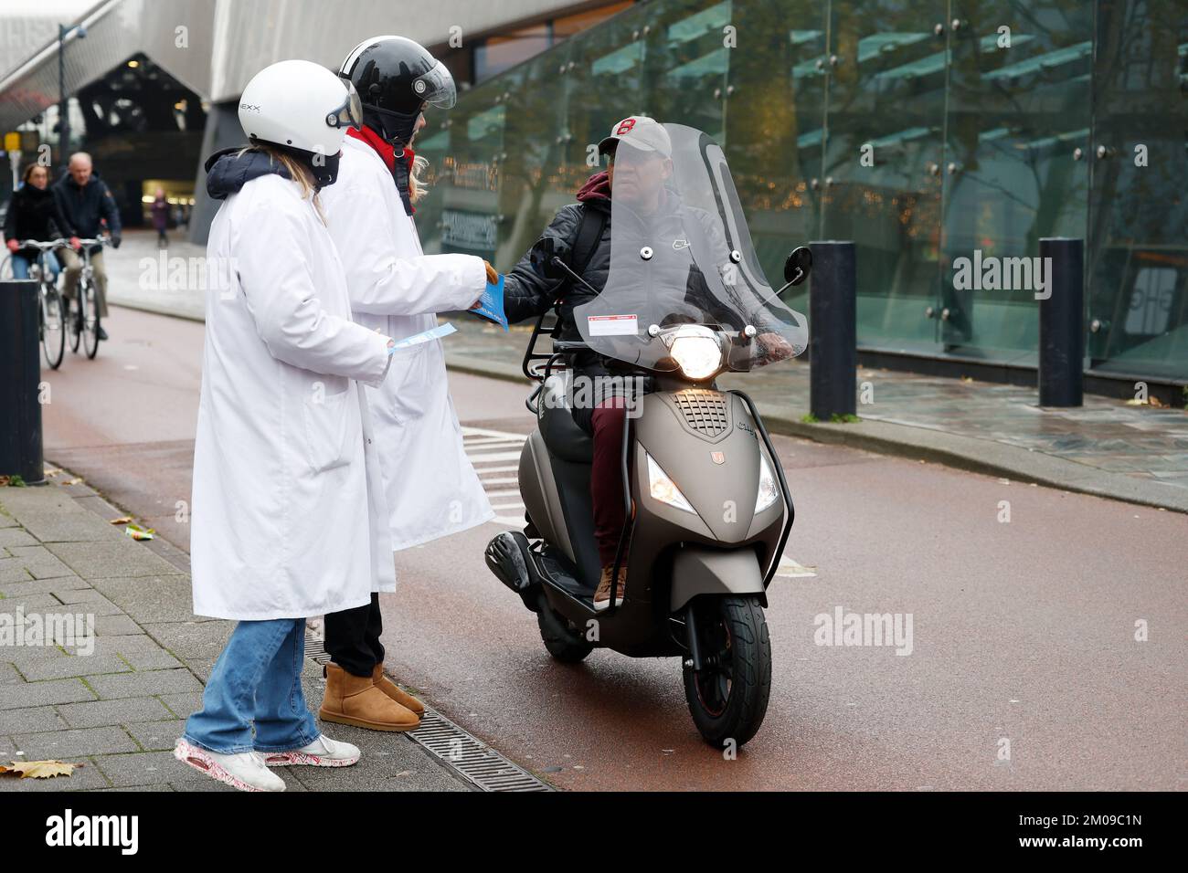 ROTTERDAM - Members of the youth organization TeamAlert are alerting light moped riders to the approaching helmet obligation for light moped riders. The 800,000 moped riders must wear a helmet as of 1 January, otherwise a fine of 100 euros is imminent. ANP BAS CZERWINSKI netherlands out - belgium out Stock Photo