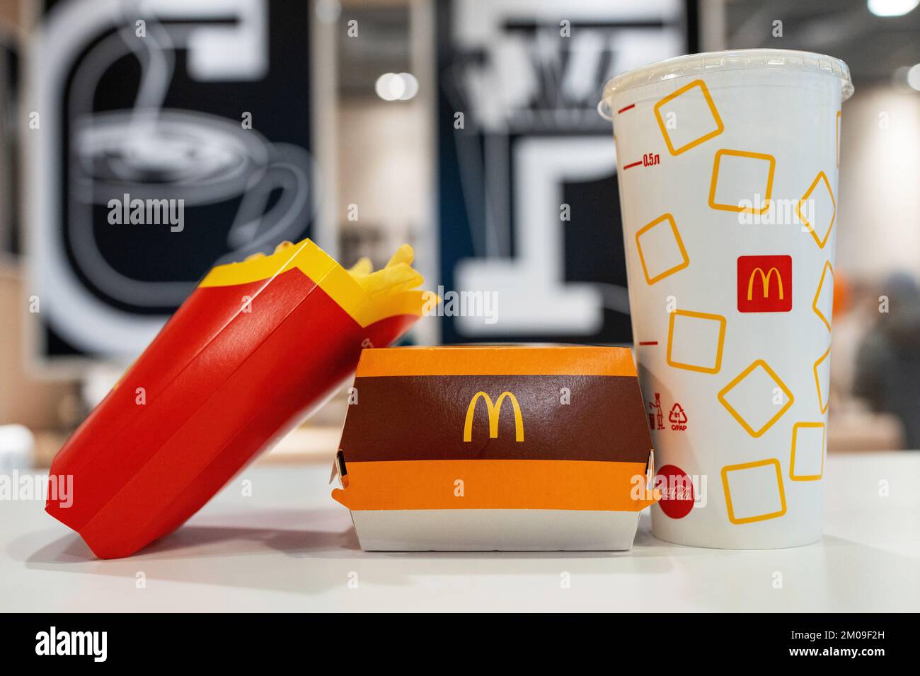 Big Mac Box with McDonald's logo, French Fries and soft drink on table in McDonald's Restaurant. Stock Photo