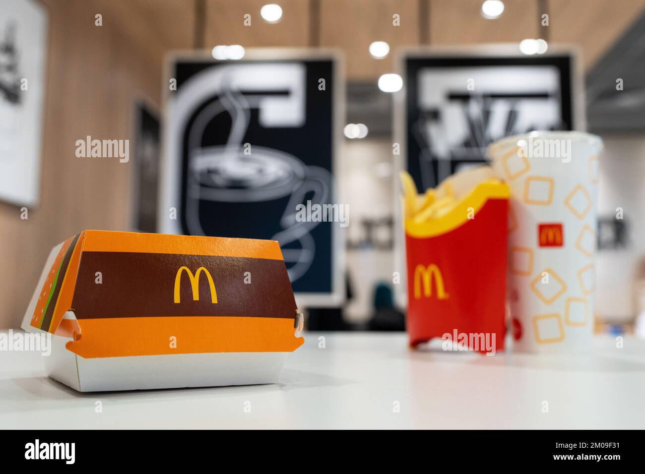 Big Mac Box with McDonald's logo, French Fries and soft drink on table in McDonald's Restaurant. Stock Photo