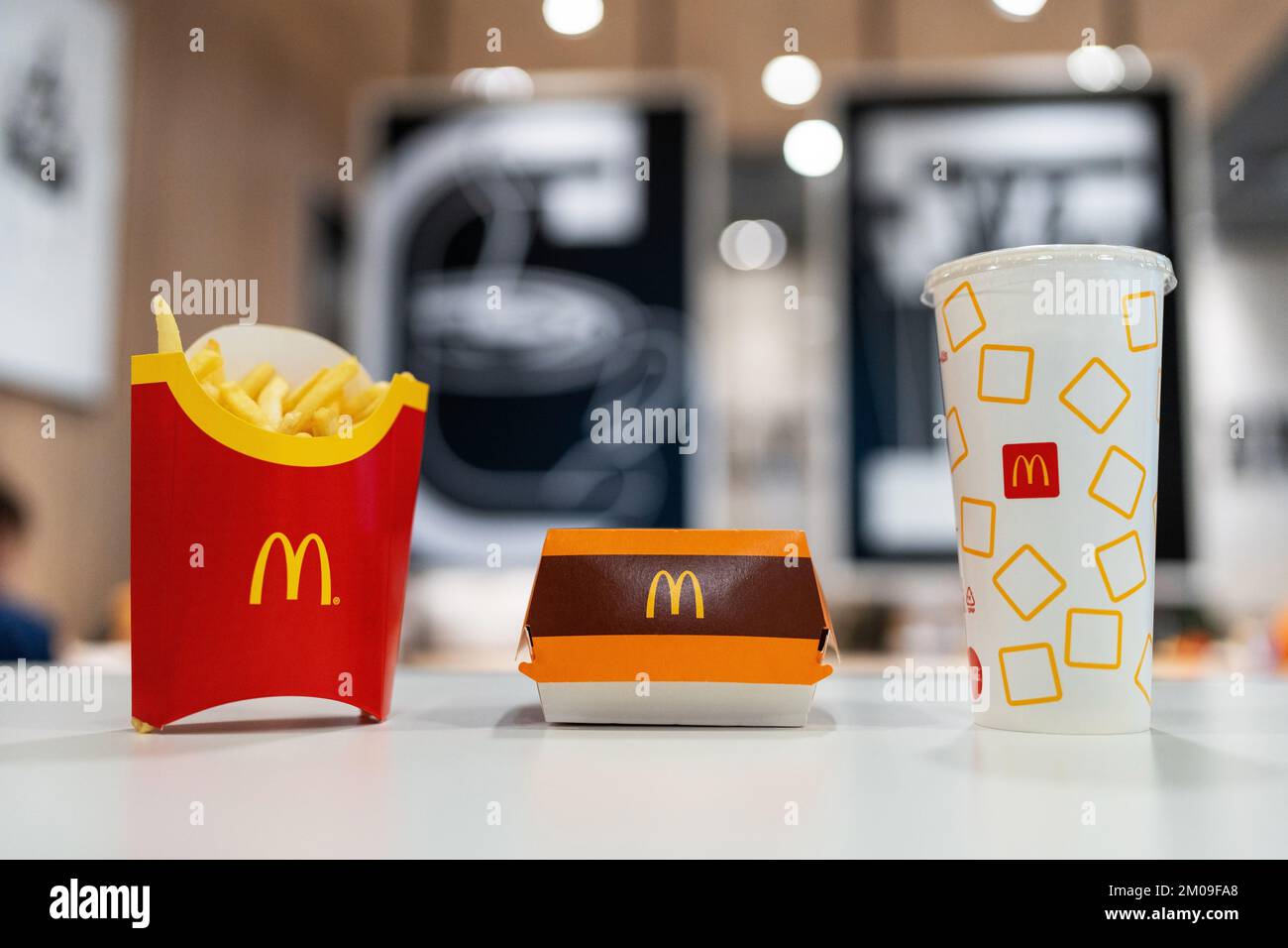 Big Mac Box, French Fries and soft drink on table in McDonald's Restaurant. Stock Photo