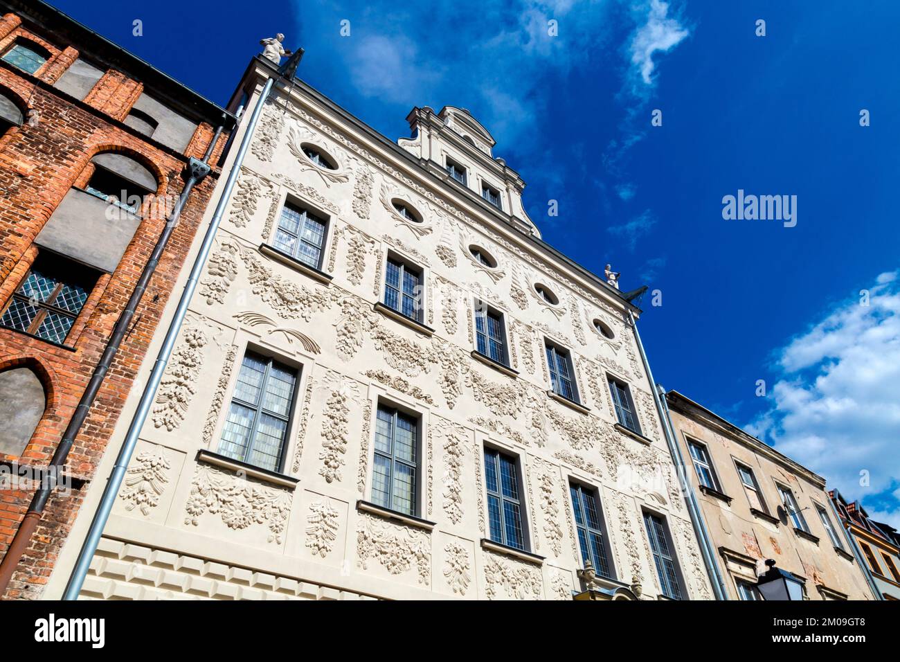 White, ornate baroque facade of the Palace of the Dąmbski Family, Torun, Poland Stock Photo
