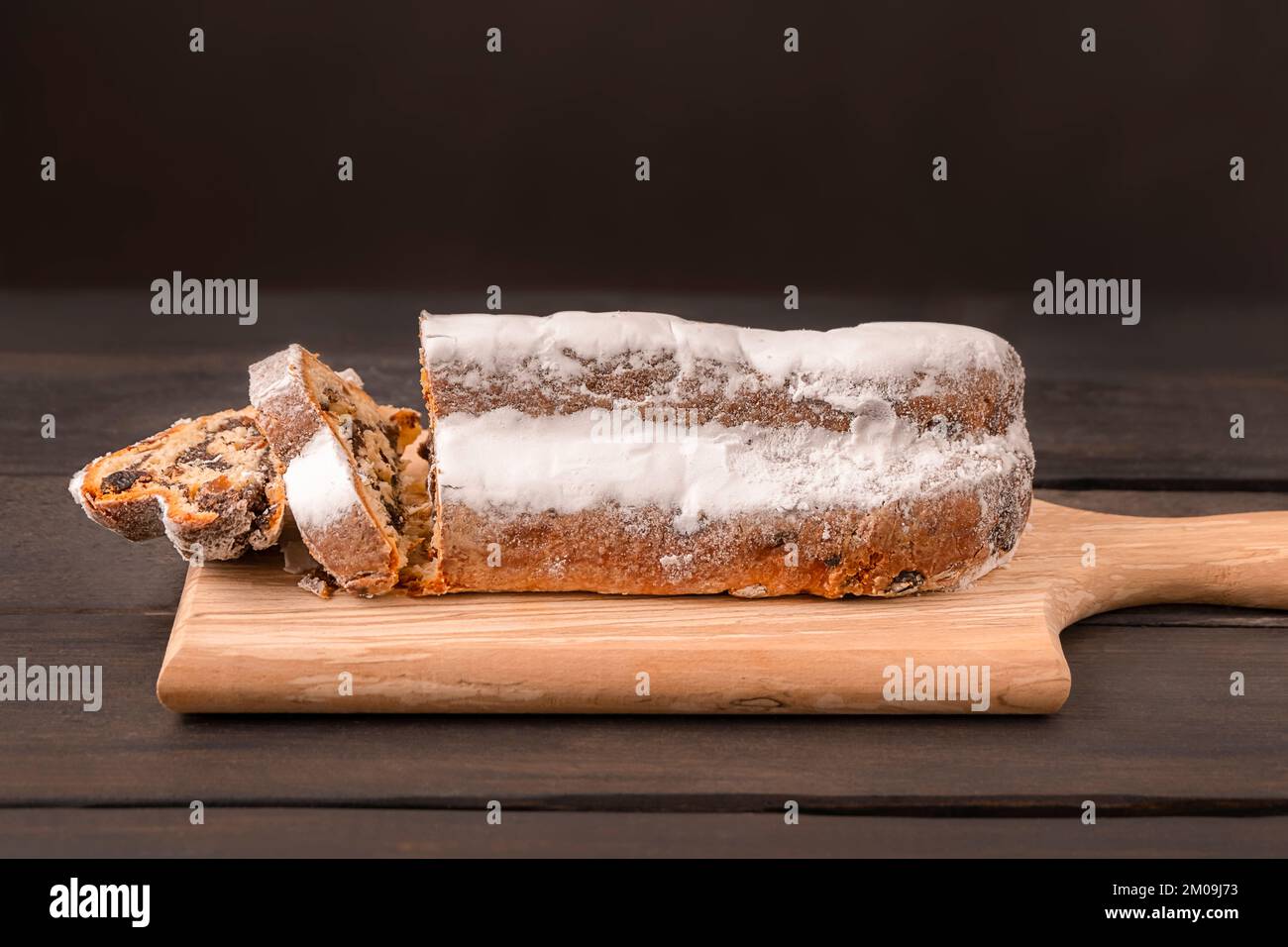 Traditional Christmas cake Stollen on dark wooden background with copy space Stock Photo