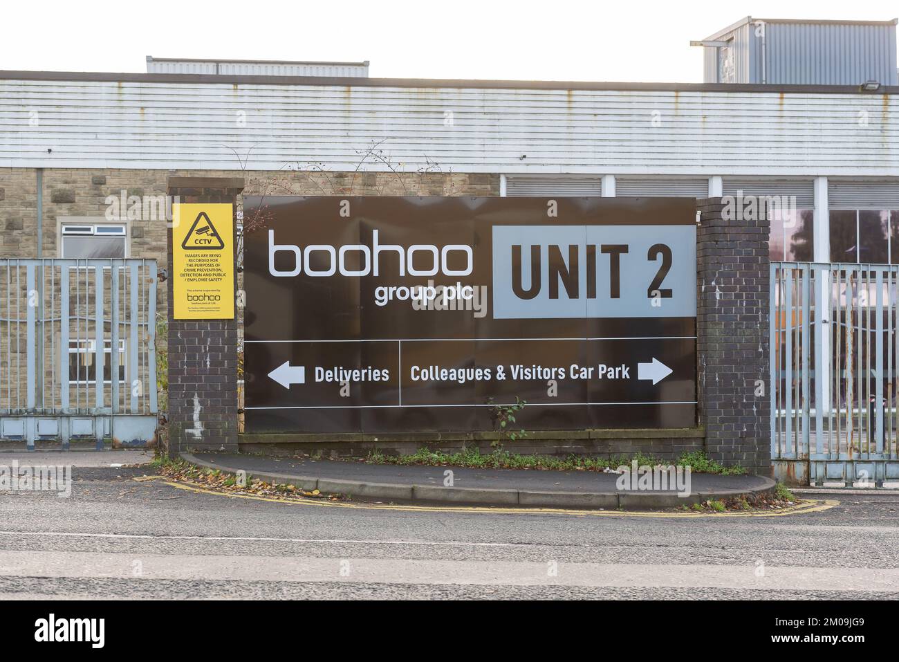 Burnley Lancashire United Kingdom. Boohoo Headquarters sign attached to the wall giving directions for deliveries. Taken on 5 December 2022 Stock Photo