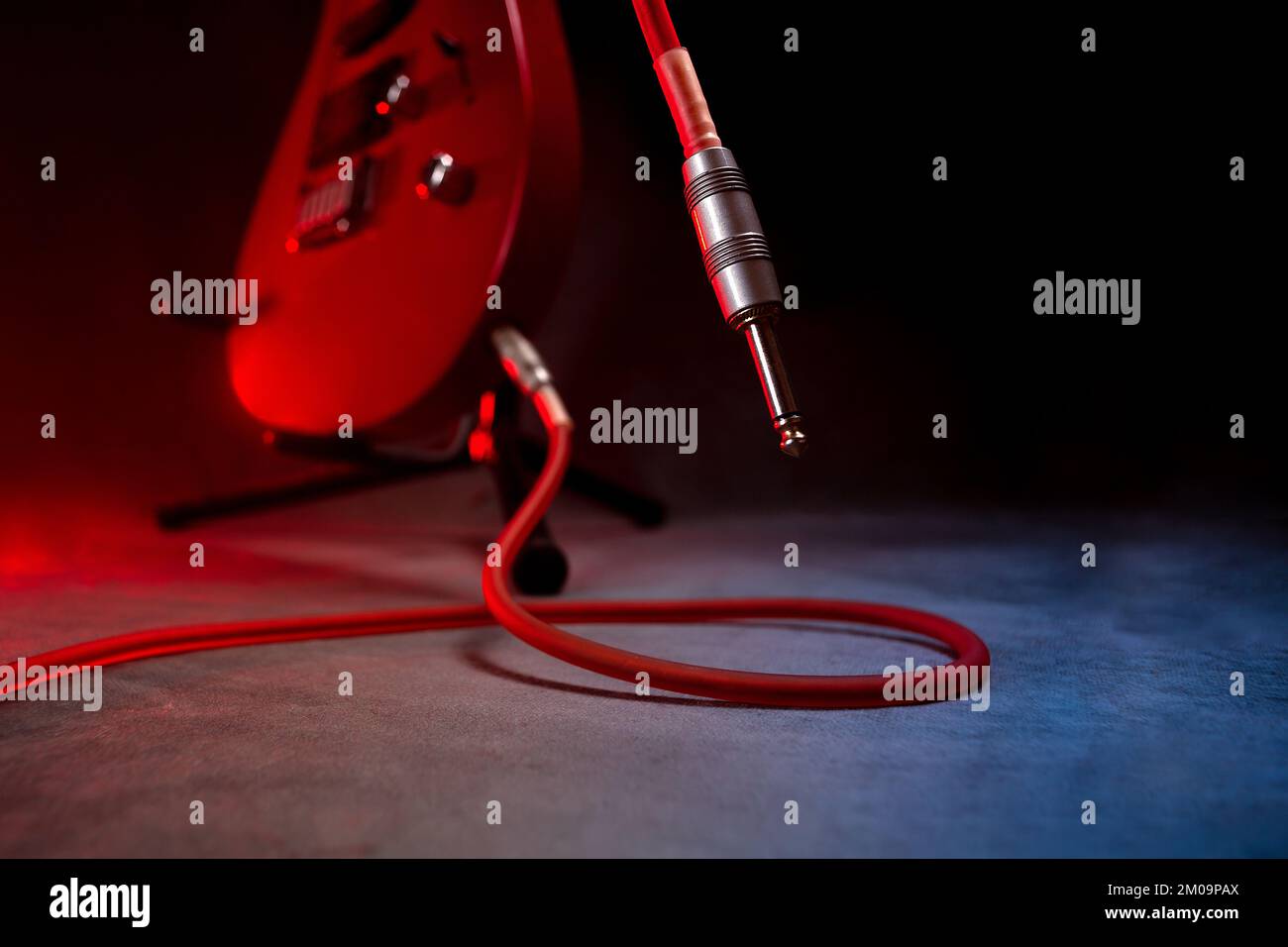 guitar pulled from the ground on the stage and the jack cable connected
