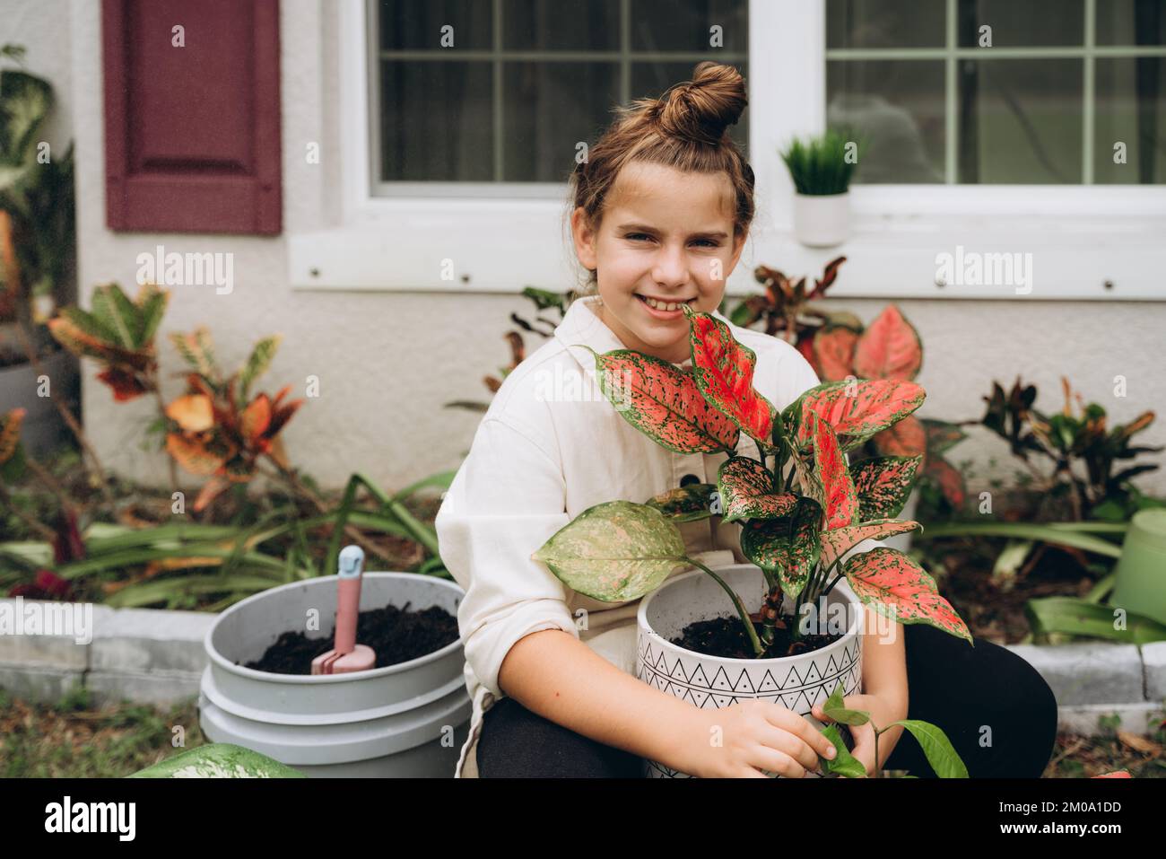 Smiling girl with a plant in a pot Stock Photo