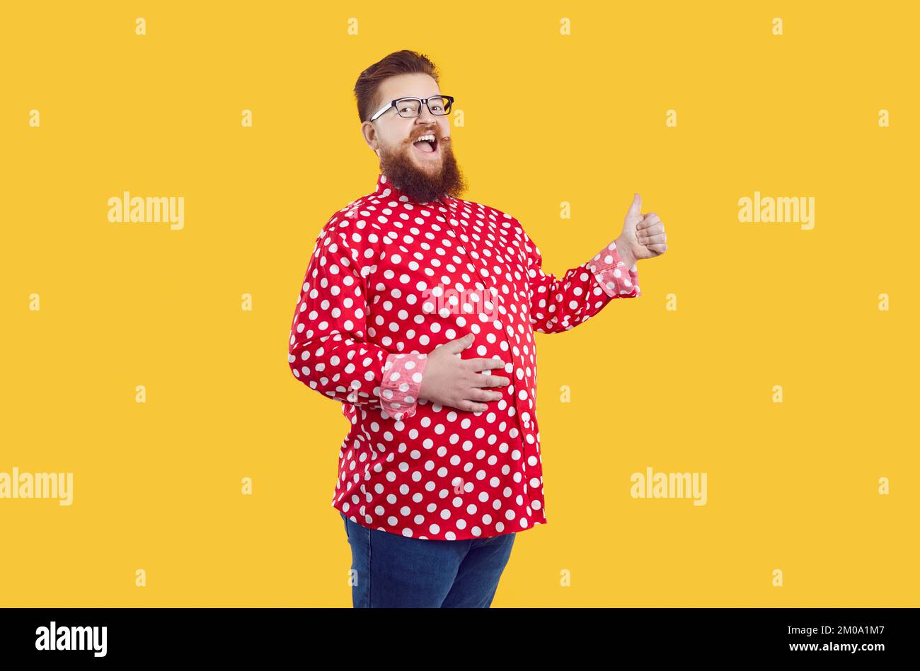 Funny cheerful fat man isolated on yellow background smiling and showing thumbs up Stock Photo