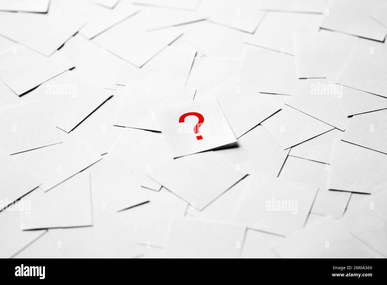 Pile of blank pieces of paper with red question mark in the middle Stock Photo