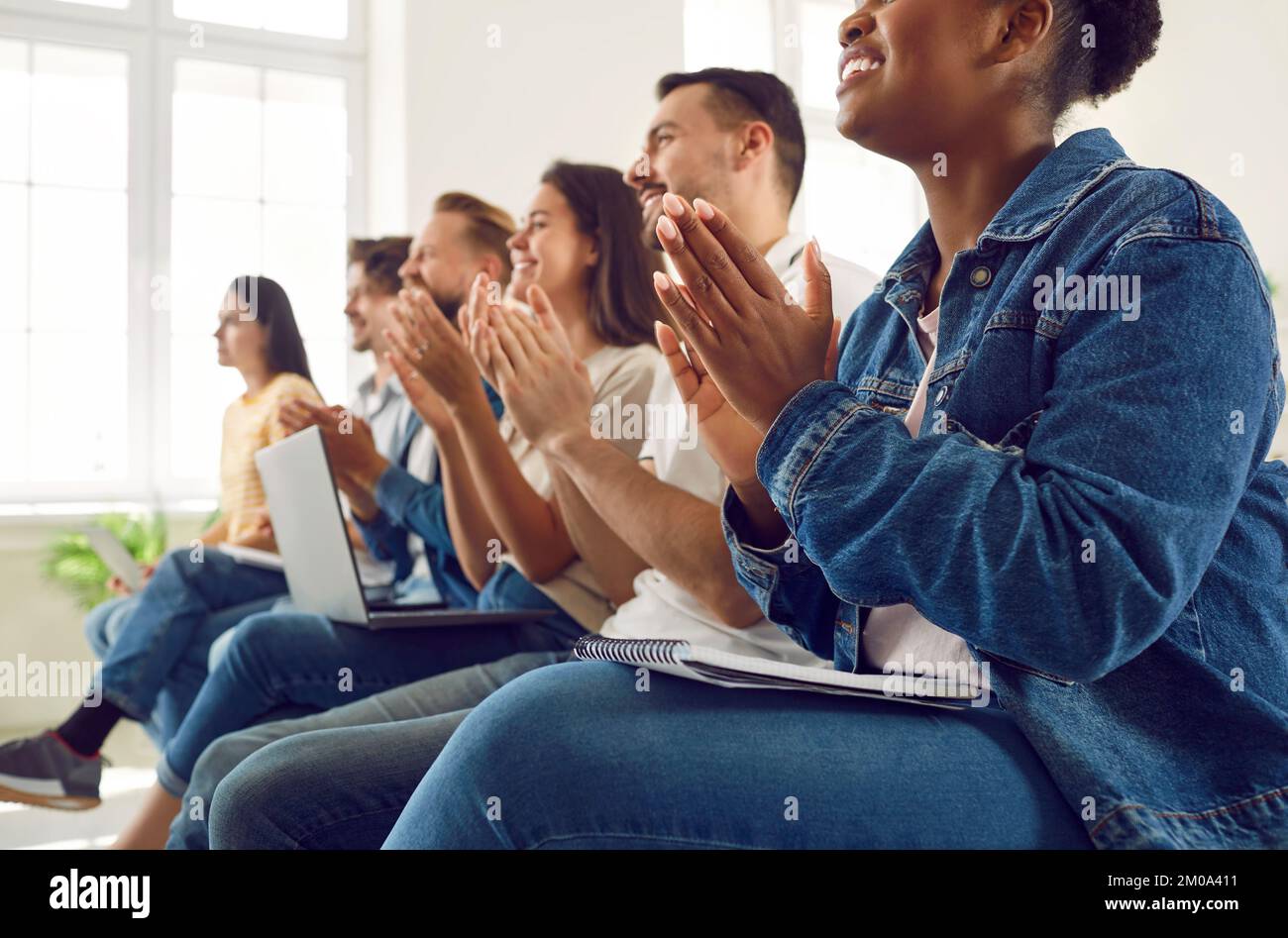 Satisfied diverse audience of students or workers applauding during lecture or seminar. Stock Photo