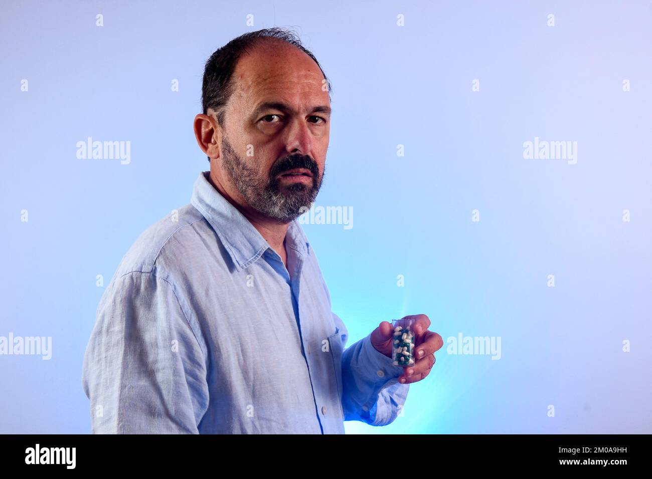 sixty year old man holding a medicine bottle Stock Photo