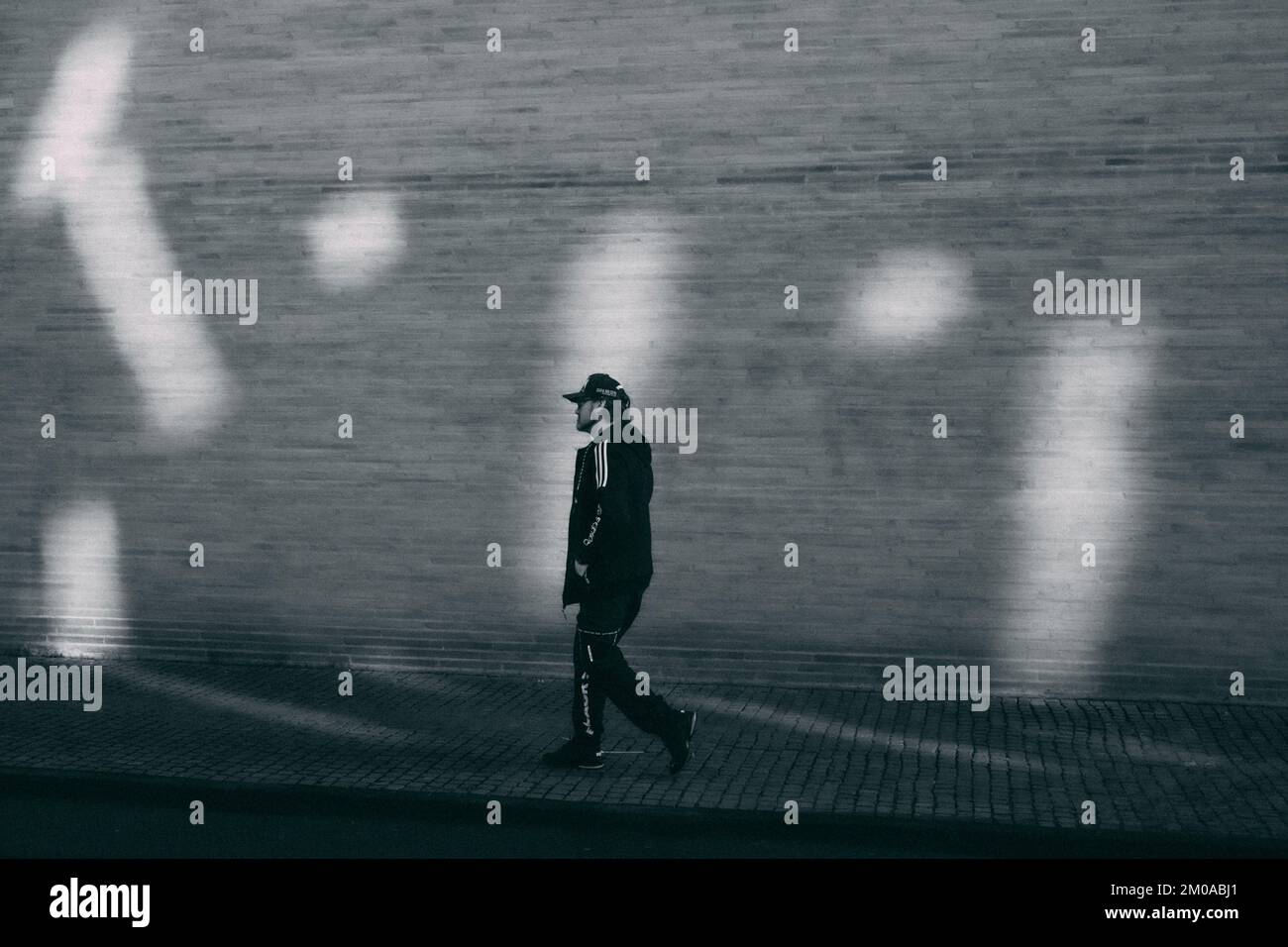 Köln, 24.11.22: Streetphotography, ein Mann geht eine mit Licht und Schatten beleuchtete Strasse entlang.  Foto: pressefoto Mika Volkmann Stock Photo