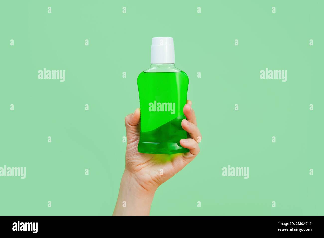 Mockup of unbranded bottle with green liquid for branding and label and