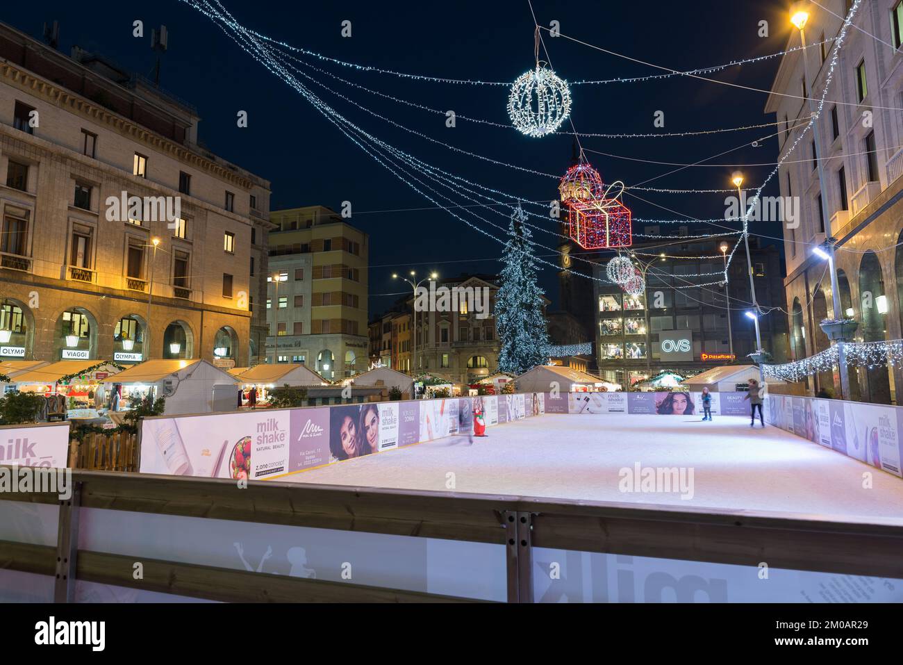 Square with ice skating rink and Christmas market with colored lights