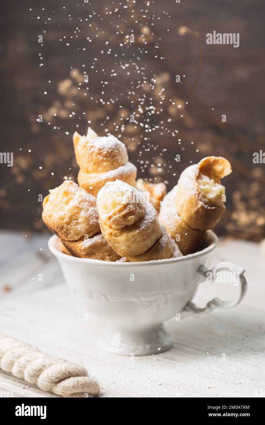 Homemade Pastry Tubes with Whipping Cream in the White Tea Cup over