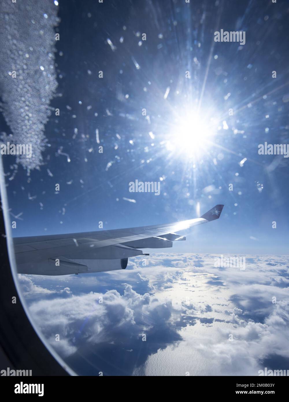 A Close-Up Of Airplane Wing Against Blue Sky and white clouds Stock Photo