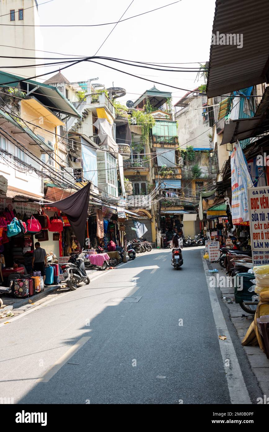 Hanoi, Vietnam - September 16, 2018: In the commercial street of the capital of Vietnam, a quiet scene with little traffic and a motorcycle driven by Stock Photo