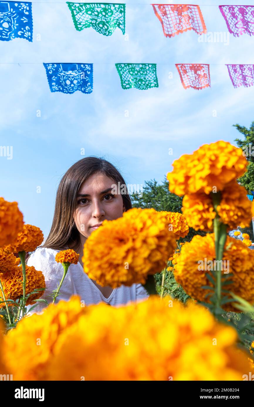 young woman whit Traditional cempasuchil flowers used for altars at day