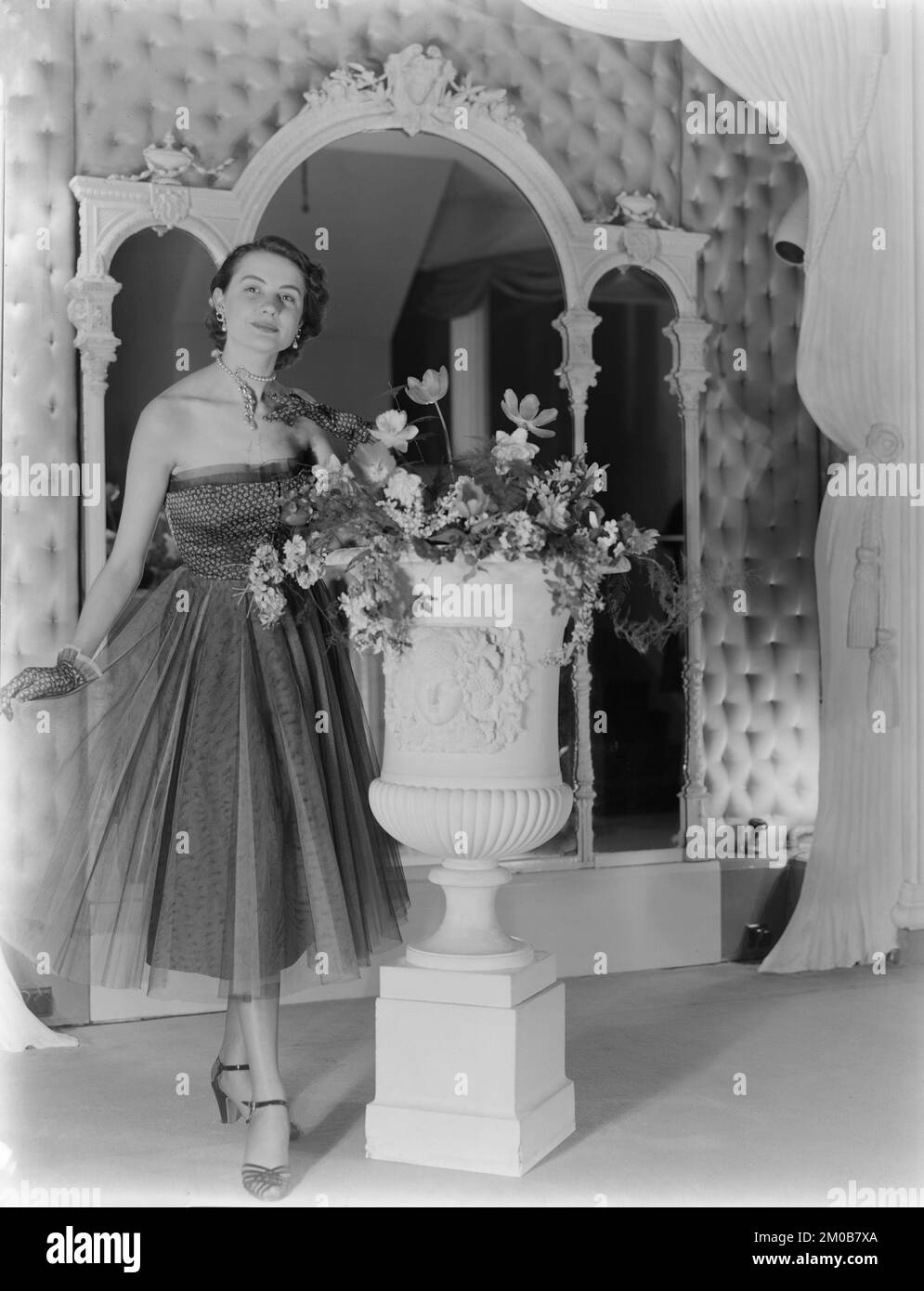 A model working for the Alexandrine Fashion and Model House in Nottingham, England, during the 1950s. She is posing in a studio, wearing one of Alexadrine's latest designs. Stock Photo