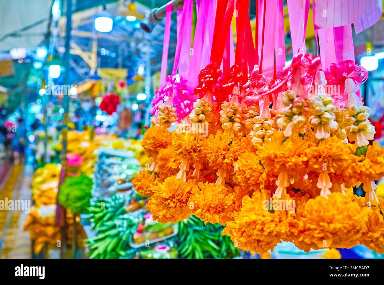 Garlands from fresh marigolds and jasmine flowers on the storefront of
