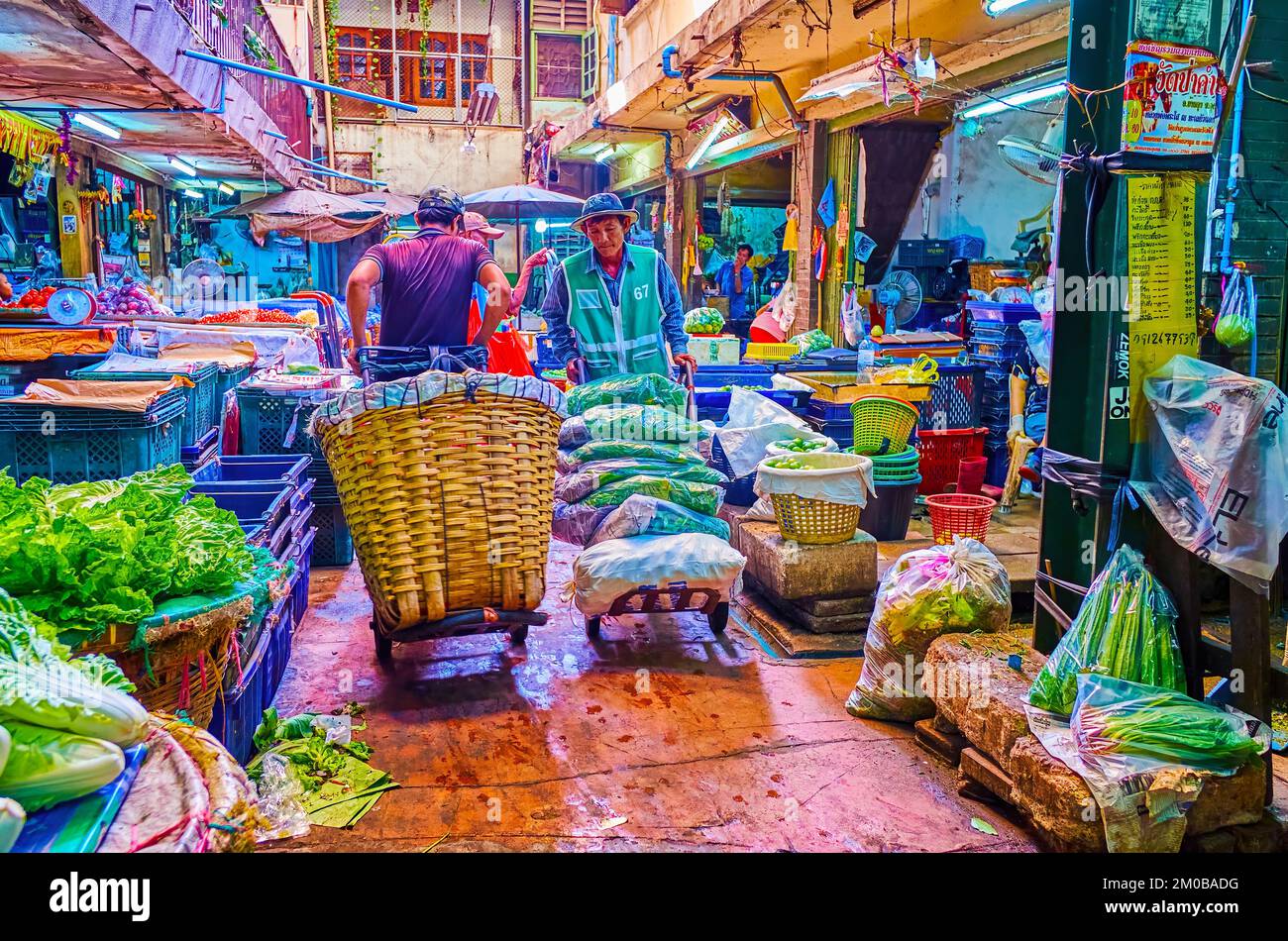 BANGKOK, THAILAND - APRIL 23, 2019: Porters carrying large baskets and  packs with agricultural products along alleys in Wang Burapha Phirom  market, on Stock Photo - Alamy